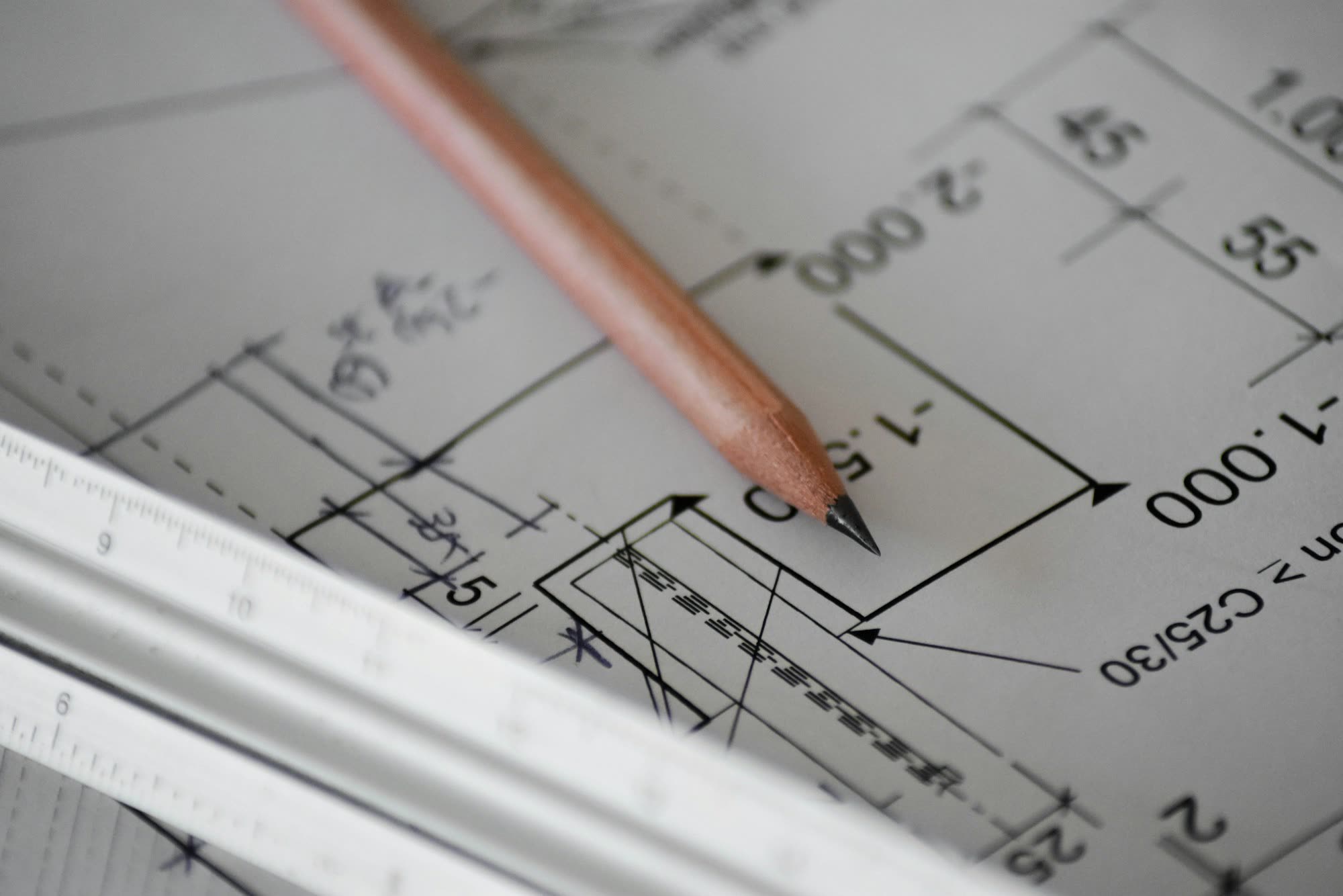 Pencil and scale ruler on a construction plan