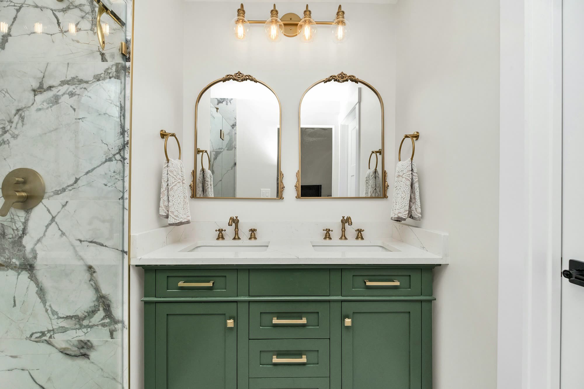 Bathroom with a green double vanity and brass fixtures
